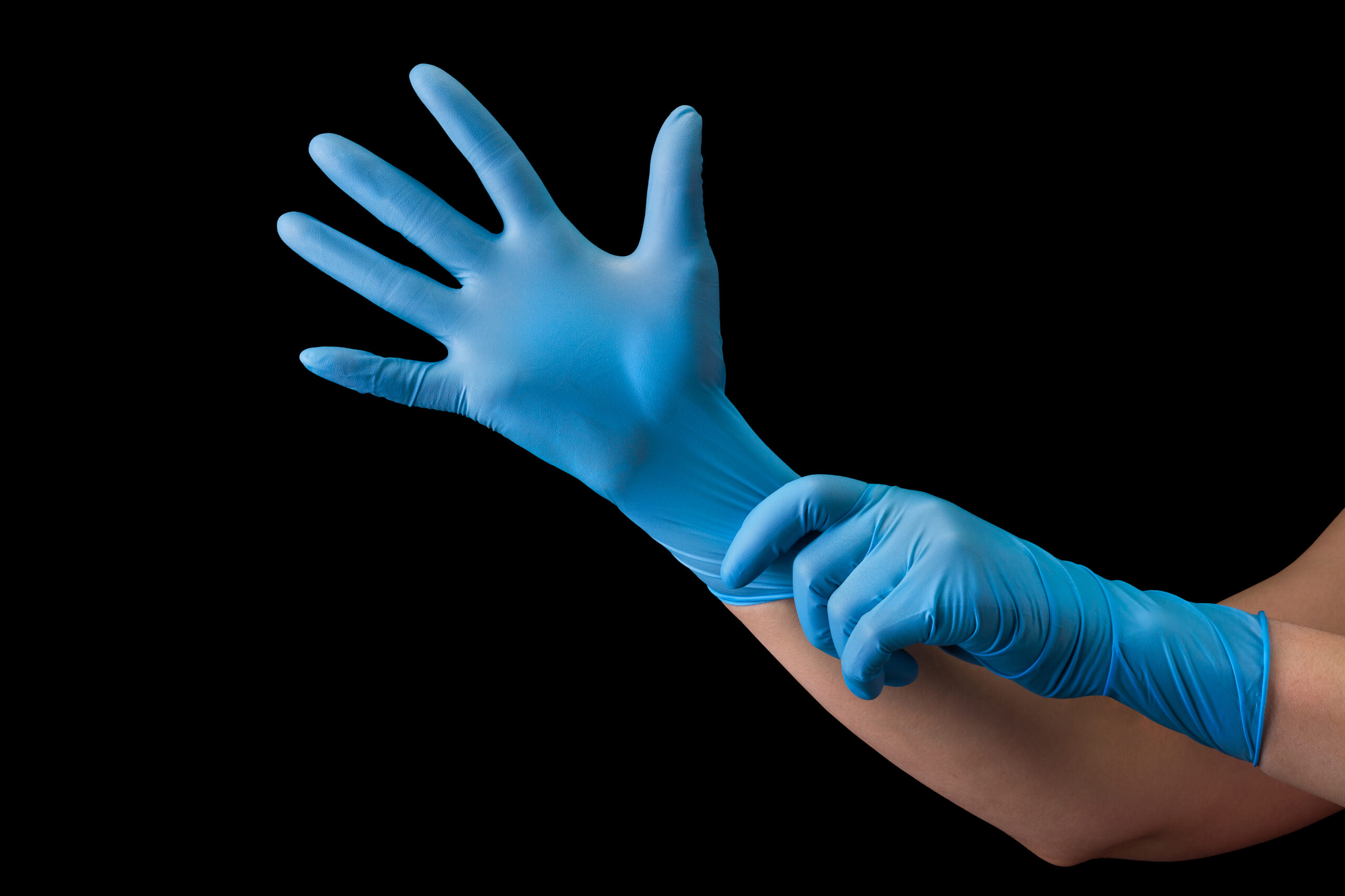 Doctor wearing a medical glove on hands isolated on black background with clipping path. Concept of protection against pandemic and viruses.